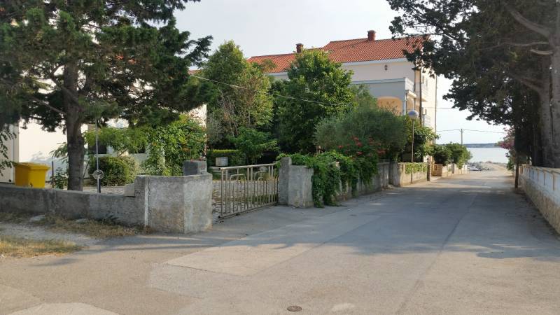 Rodinný dům v obci Vrsi s okolní zelení a výhledem na moře.