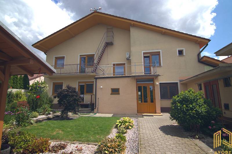 Rodinný dům na Športové ulici v Brodském s trávníkem a květinovou zahradou.