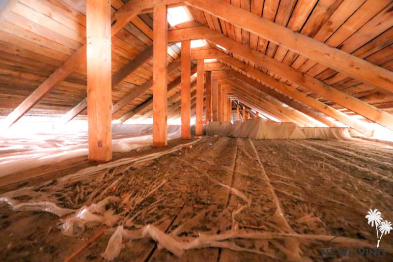 Podkroví s dřevěnou konstrukcí a izolačními materiály v obchodních prostorách.