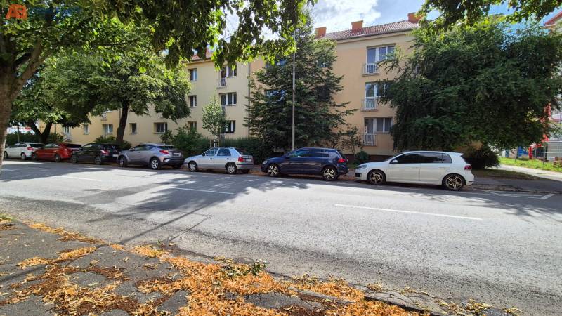 Budova na ulici Pod Párovcami v Piešťanech, obklopená stromy a zaparkovanými auty.