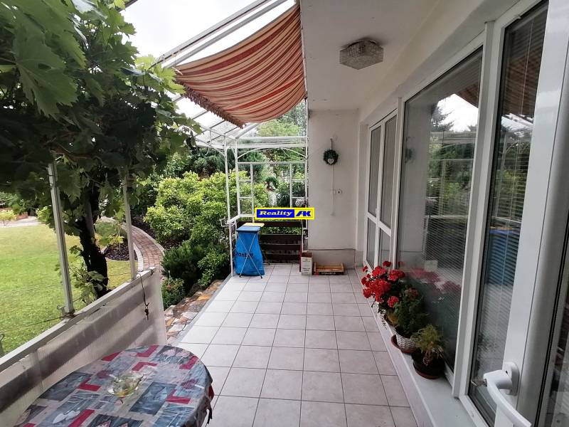 Terasa rodinného domu na ulici J.Š.Šikuru v Martině s květinami a stolem.