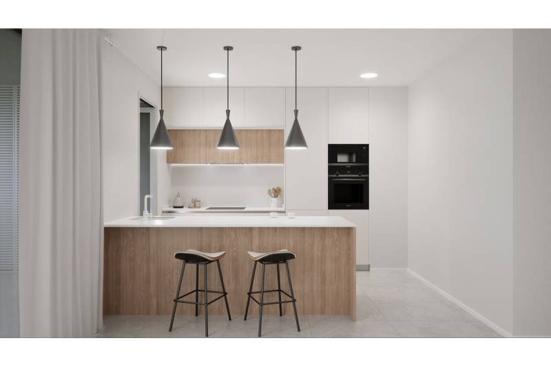 Kuchyně rekreačního apartmánu s ostrovem, židlemi a závěsnými světly.