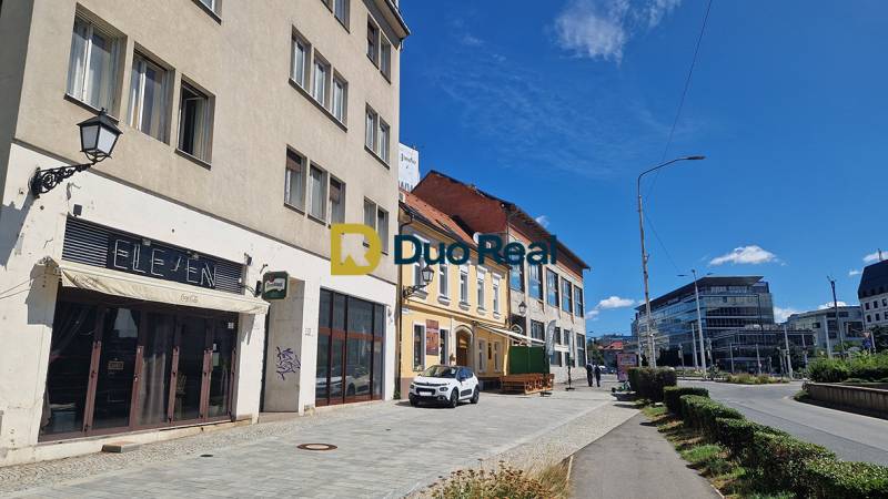 Obchodní prostory na Konventní v Bratislavě - Starém Městě s auty a chodci.