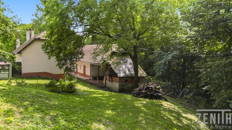 Rodinný dům na Dzurákovci v Brezové pod Bradlom obklopený zelení a stromy.