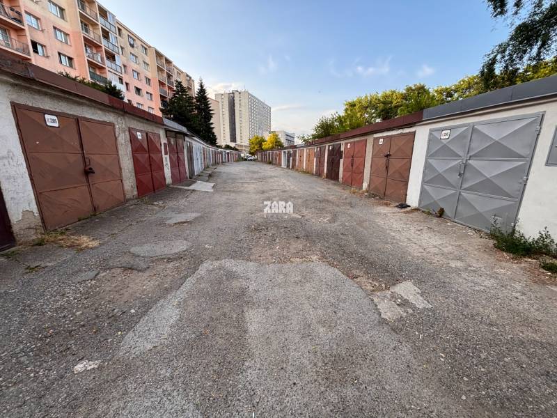 Garáže na Považské ulici v Košicích, městská část Západ, lemují panelové domy.