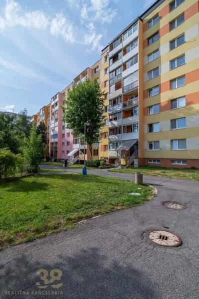 Bytový dům na Záborského ulici v Popradu, obklopený zelení a chodníky.