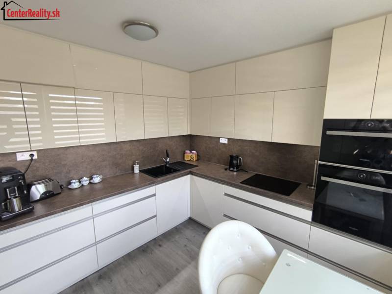 Kuchyně ve 3-pokojovém bytě, moderní linka a spotřebiče, světlé odstíny.