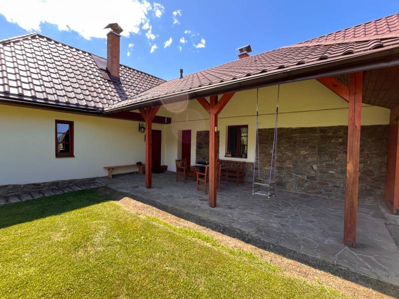Zahrada rodinného domu s terasou, židlemi a houpačkou ve městě Vagrinec na ulici Vagrinec.