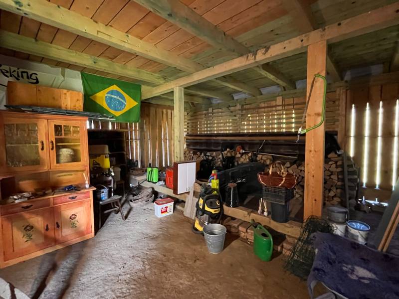 Interiér garáže v rodinném domě s různým nářadím a brazilskou vlajkou na stěně.