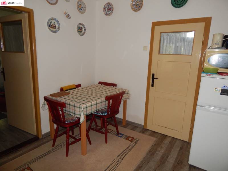 Jídelna v chatě s dřevěným stolem a kulatými dekoracemi na stěně.