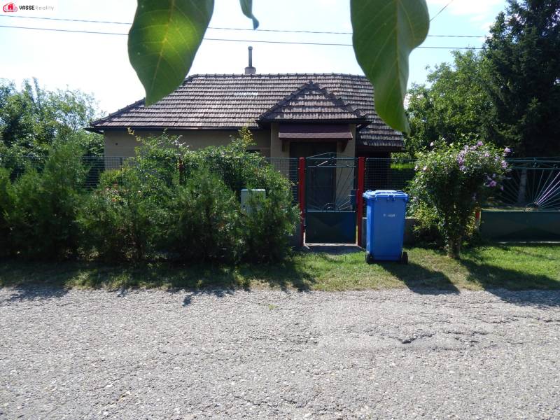 Exteriér chaty v Klížskej Nemej, obklopený zelení a brankou.