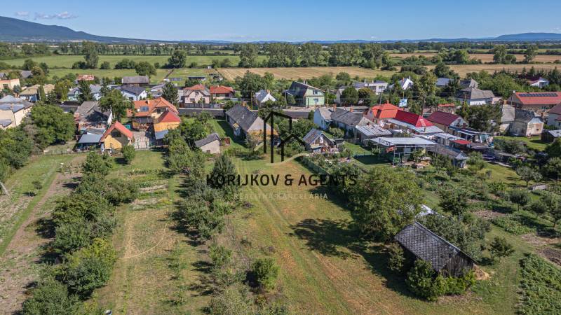 Letecký pohled na Pozemky - bydlení v Sečovcích obklopené zelení a rozptýlenými domy.