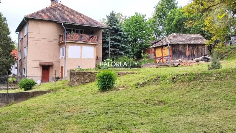 Rodinný dům v Českých Brezovách s upravenou zahradou a dřevěnou přístavbou v pozadí.