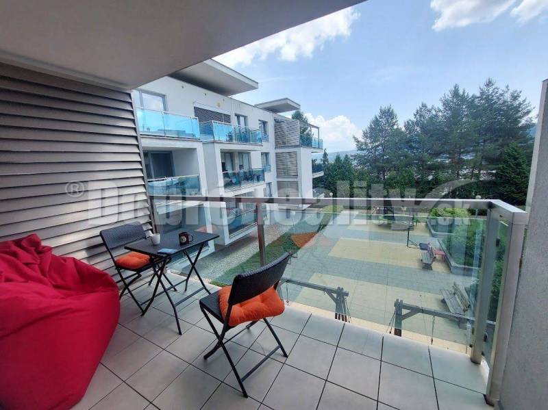 Balkon v 2-pokojovém bytě v Banské Bystrici s výhledem na dvůr a stromy.