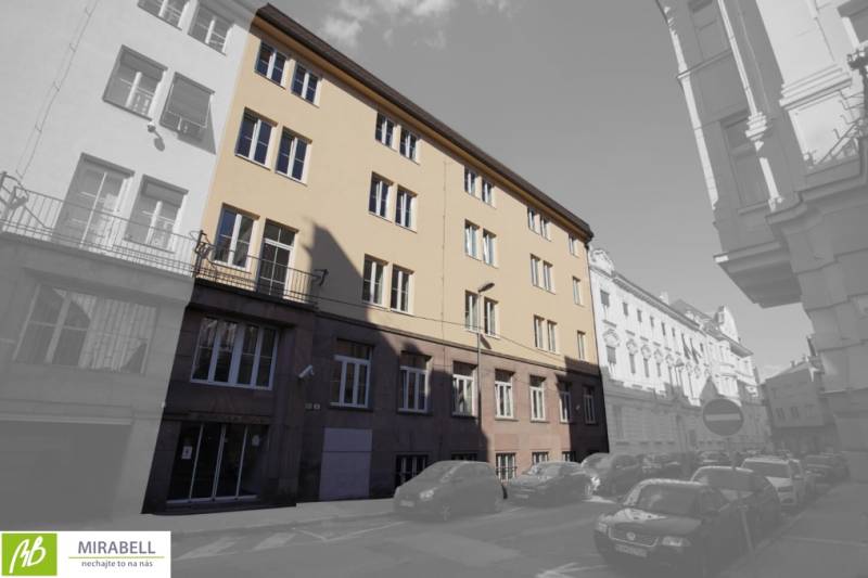 Budova na Gunduličově ulici v Bratislavě - Staré Město obklopená auty v řadové zástavbě.