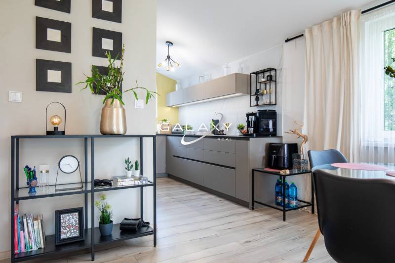 Interiér rodinného domu s otevřenou kuchyní, moderním nábytkem a dekoracemi.