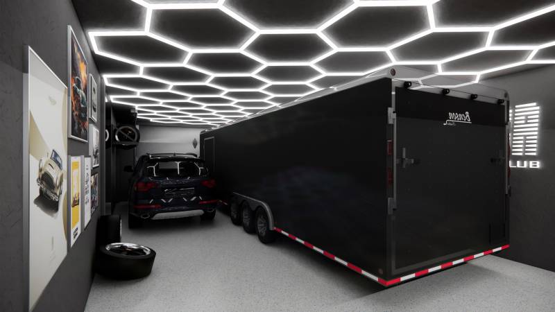 Obchodní prostory s automobilem, přívěsem, světelným stropem a uměleckými plakáty na zdi.
