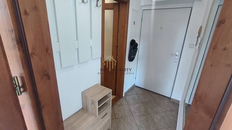 Předsíň 2pokojového bytu s vestavěnou skříní, dlažbou a dveřmi s imitací dřeva.
