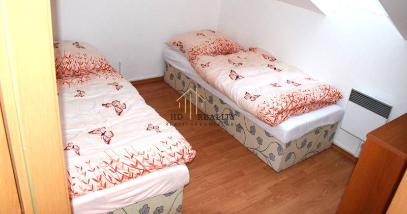 Dětský pokoj ve 3-pokojovém bytě se dvěma lůžky a jednoduchou dřevěnou podlahou.