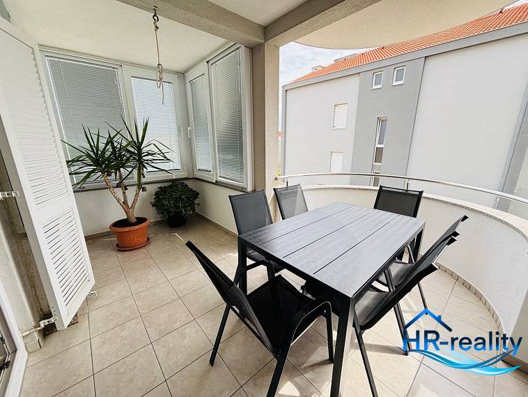 Balkon 3-pokojového bytu v Novalji, s květinami a zahradním nábytkem na dlažbě.