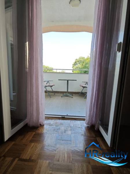 Výhled z 2pokojového bytu na balkon s posezením a výhledem na přírodu.