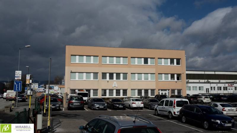 Budova s kancelářemi, parkoviště a auta na Pestovatelské ulici v Bratislavě - Ružinově.