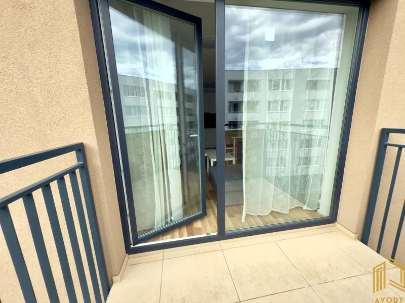 Balkon s posuvnými dveřmi do 2-pokojového bytu, výhled na ulici.