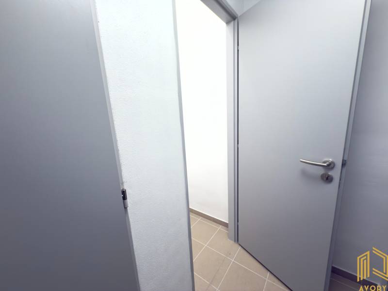 Otevírání bílých dveří na chodbě v 2-pokojovém bytě s dlažbou.