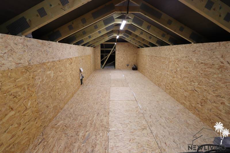Podkroví rodinného domu s dřevěnými panely a viditelnou konstrukcí.