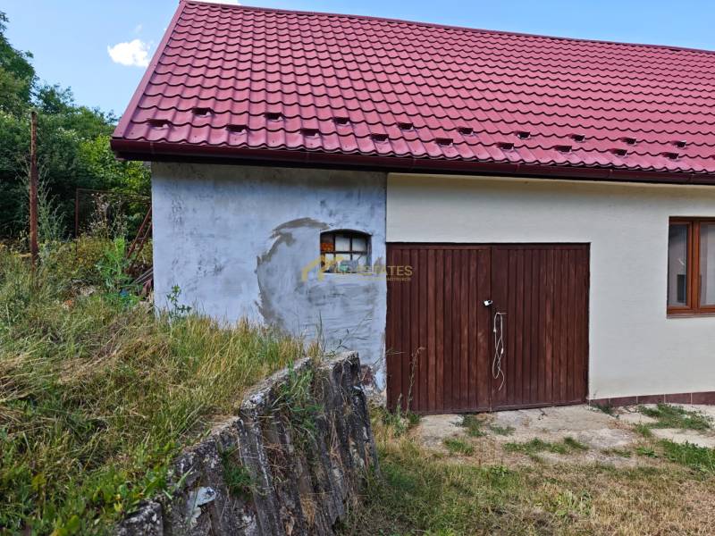 Rodinný dům na Dlouhé ulici ve Vranově nad Topľou s červenou střechou a dřevěnou garáží.