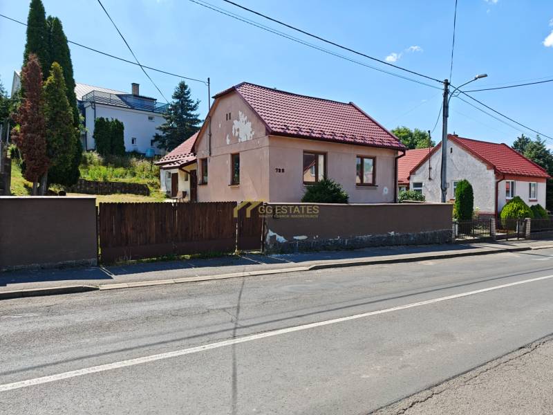 Rodinný dům na Dlouhé ulici ve Vranově nad Topľou s červenou střechou a dřevěným plotem.