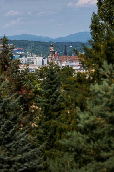 Panoráma Košic s pohledem na historické budovy obklopené zelení a horami v pozadí.
