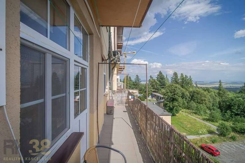 Balkon 3pokojového bytu ve Vysokých Tatrách s výhledem na přírodu a parkoviště.