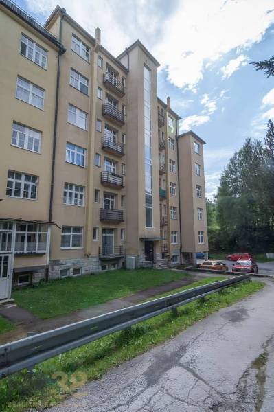Pětiposchoďový bytový dům ve Vysokých Tatrách s přístupovou cestou a parkováním.