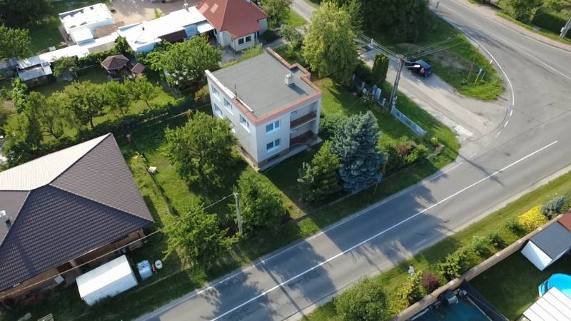 Rodinný dům v Rakoľubech v Novém Městě nad Váhem obklopený zelení a ulicí.