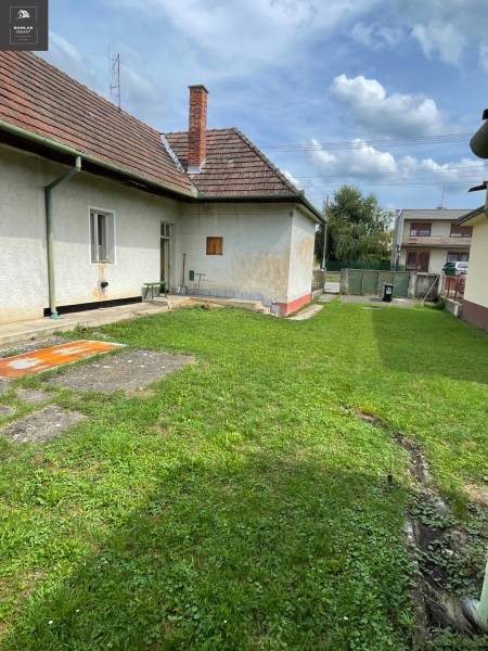 Rodinný dům v Trenčianských Stankovcích s udržovaným trávníkem a tradiční šikmou střechou.