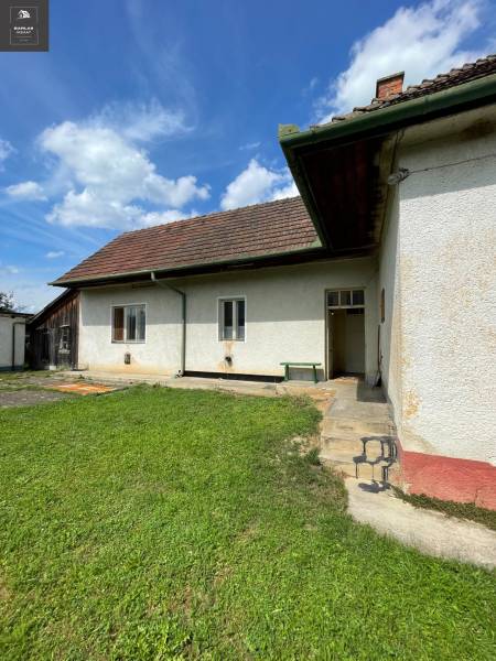 Rodinný dům v Trenčianských Stankovcích s trávníkem a tradiční střechou pod modrou oblohou.