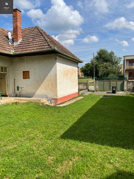 Rodinný dům v Trenčianských Stankovcích s travnatým pozemkem a cihlovou střechou.