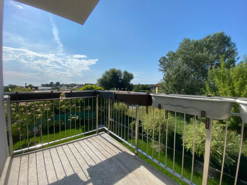 Balkon rodinného domu ve Vojce nad Dunajem s výhledem na zelenou zahradu.