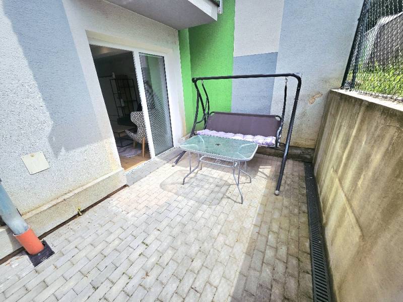 Terasa s houpačkou a stolkem v Bánovcích nad Bebravou u 1-pokojového bytu.