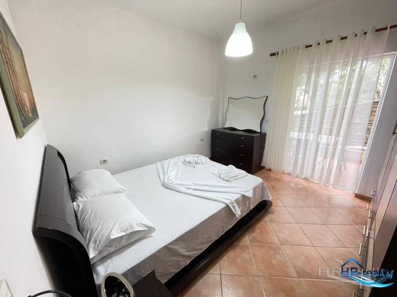 Ložnice v rekreačním apartmánu s manželskou postelí, komodou a balkonem.