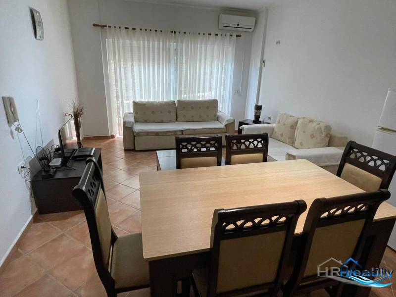 Obývací pokoj s jídelním stolem a pohovkou v rekreačním apartmánu.