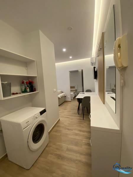 Praktické uspořádání s pračkou a jídelním stolem v Rekreačním apartmánu.