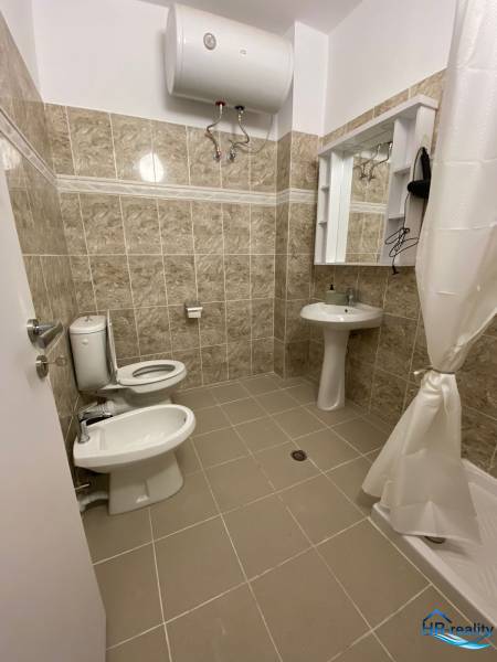Koupelna v rekreačním apartmánu; umyvadlo, zrcadlo, toaleta, bidet a ohřívač vody.