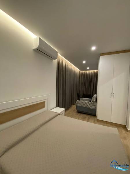 Rekreační apartmán s postelí, skříní, klimatizací a pohovkou.