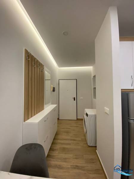Útulný interiér rekreačního apartmánu s pračkou a úložným prostorem.