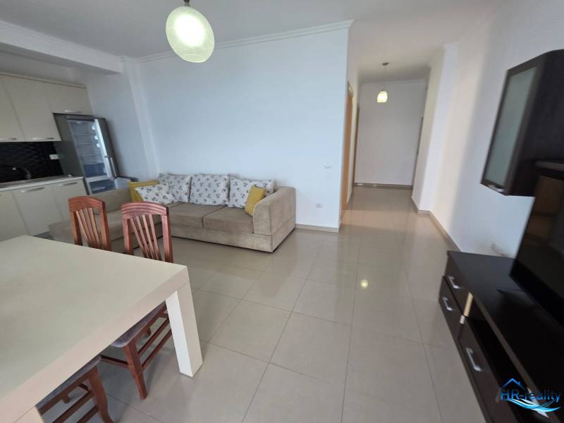 Světlý obývací pokoj s kuchyňským koutem, pohovkou a jídelním stolem v Rekreačním apartmánu.