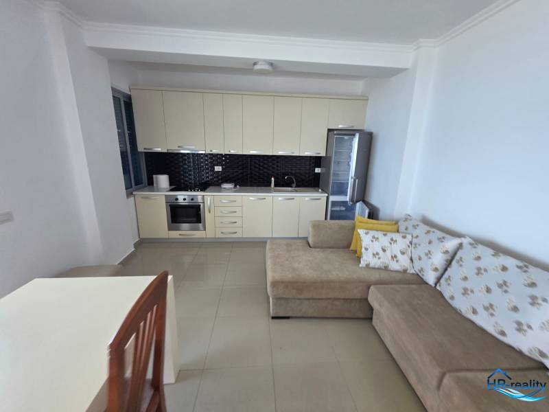 Rekreační apartmán s kuchyňskou linkou, pohovkou a jídelním stolem.