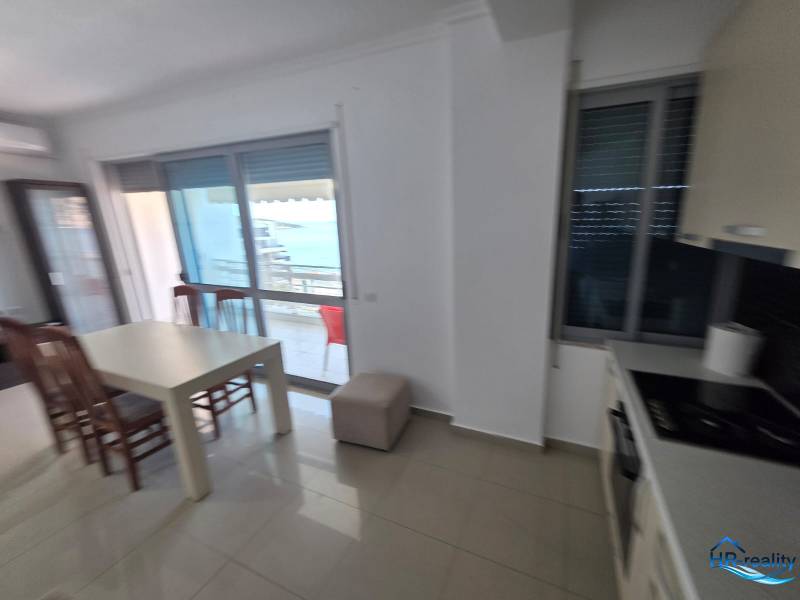 Jídelní kout s výhledem na moře v rekreačním apartmánu, světlé interiérové zařízení.