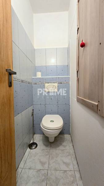 Toaleta se světle modrými kachličkami v 3-pokojovém bytě.